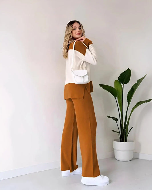 Woman wearing a white and brown outfit with a plant in the background
