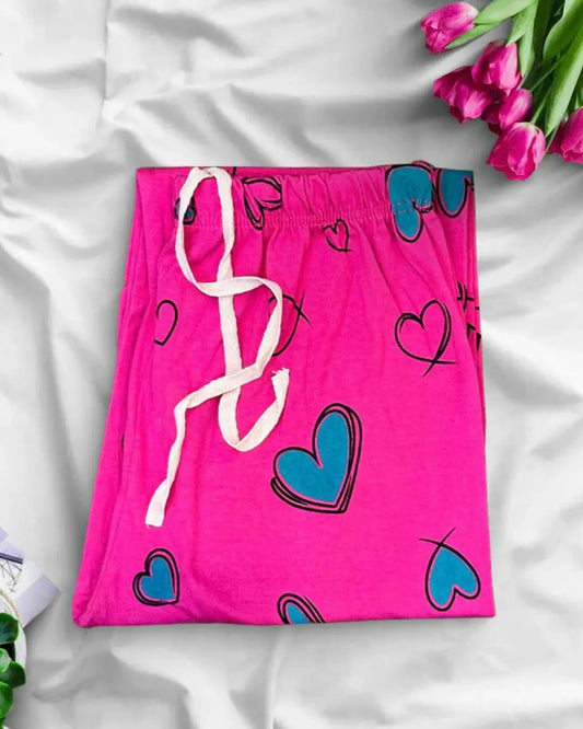 Pink lounge trousers with green heart print and a white drawstring.