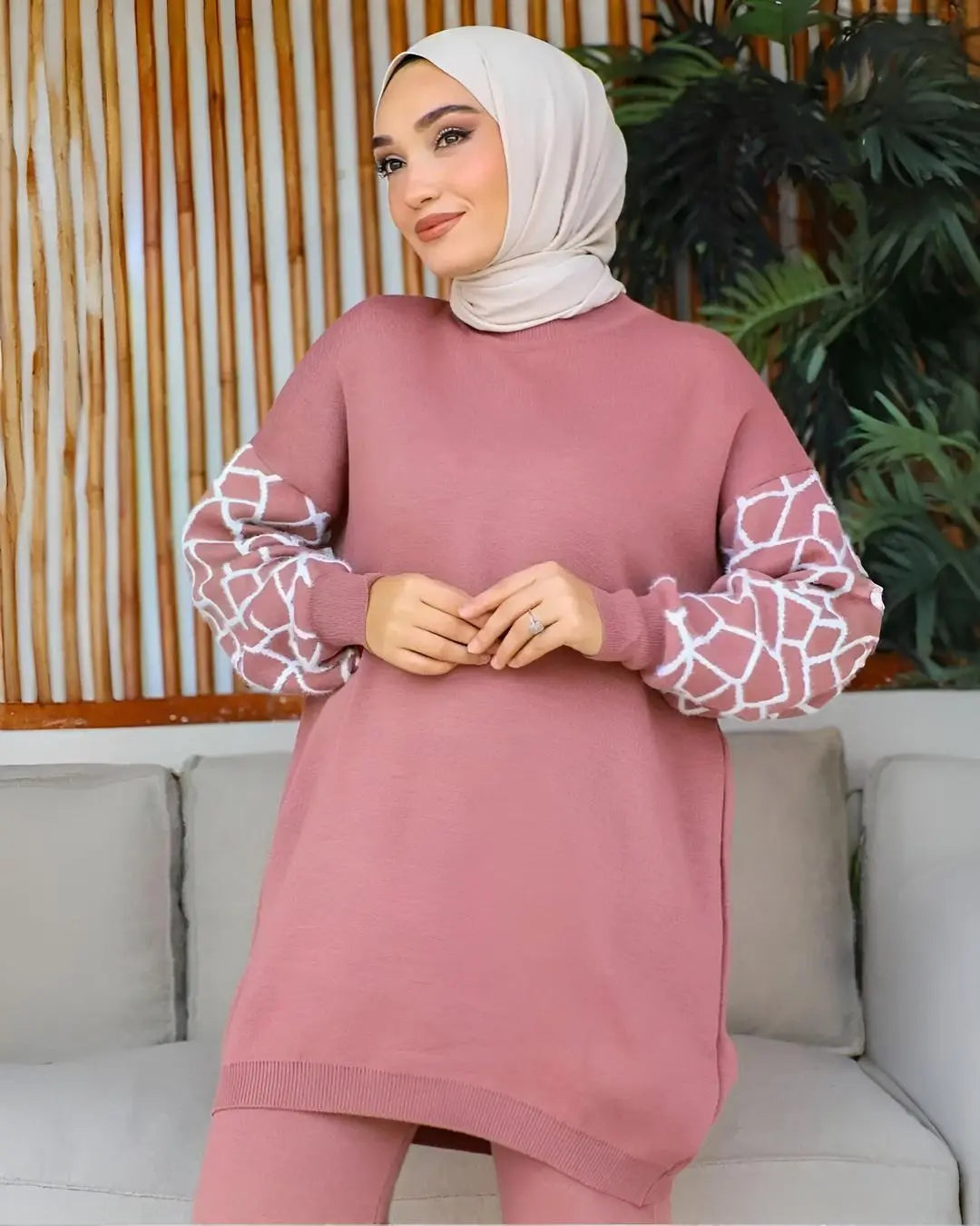 A women wearing a long-sleeved winter co-ord set with a cute giraffe print on the top and trousers.