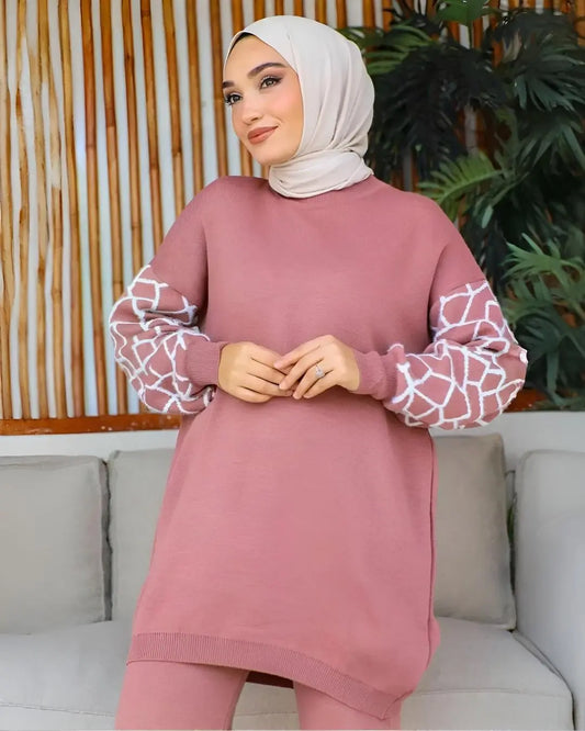 A women wearing a long-sleeved winter co-ord set with a cute giraffe print on the top and trousers.